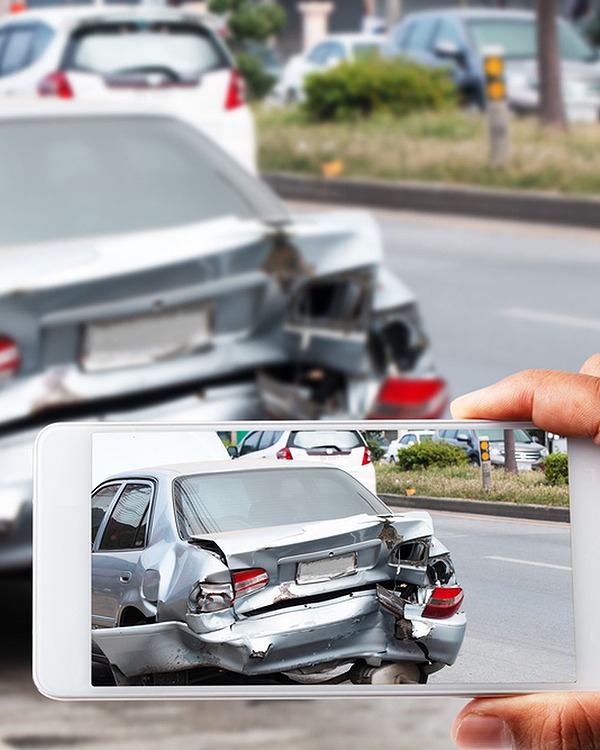 a phone screen taking a picture of a car that was damaged in a car accident